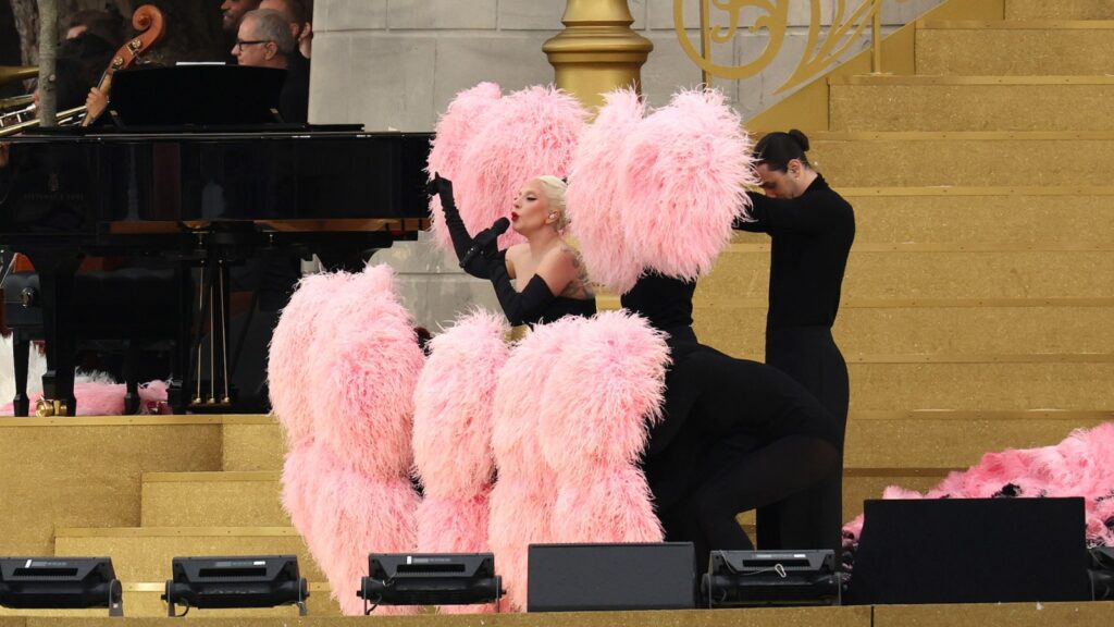 Lady Gaga Sings In French, Bustles With Feathers At Olympics